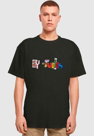 Sort bomuld t-shirt med farverige trykte bogstaver, der staver "2Y Studios." Designet inkluderer forskellige teksturer og mønstre i bogstaverne.