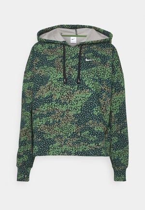 Dunkelgrüner Nike Hoodie mit Camouflage-Muster, weißen Sprenkeln, schwarzen Kordeln und kleinem weißen Nike Swoosh auf der Brust.