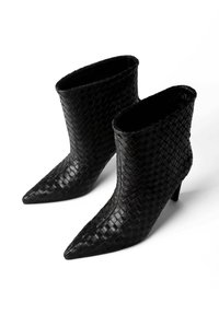 Czarne plecione skórzane botki za kostkę z szpiczastymi noskami i średniej wysokości obcasami, z wyraźnym wzorem i gładkim wykończeniem wnętrza.