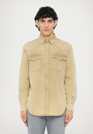 Chemise en denim beige avec fermeture à boutons, deux poches poitrine à rabat et boutons-pression métalliques ; design d'empiècement style ranch.