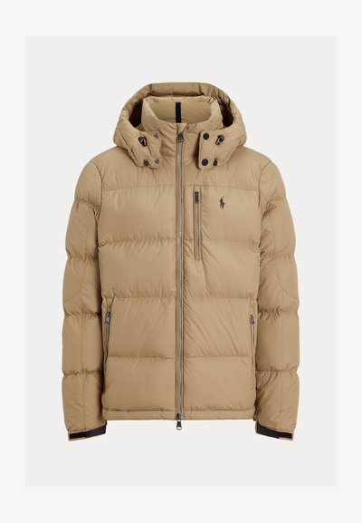 Beżowa kurtka puchowa z kapturem, z zamkiem błyskawicznym z przodu i dwiema bocznymi kieszeniami. Pikowana konstrukcja z czarnymi akcentami i małym logo na klatce piersiowej.