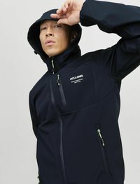 Marineblauwe hoodie met een rits aan de voorkant en ritssluitingen in de zakken. Voorzien van groene accenten en logo-tekst op de borst. Soepele stoftextuur.