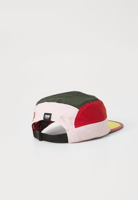 Bunt gemusterte Kappe mit einem Design in Rot, Olivgrün und Pink. Die Vorderseite hat einen flachen Schild, und der hintere Teil ist aus Netzmaterial mit einem verstellbaren Riemen.