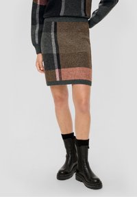 Stickad rutig kjol i bruna, grå och rosa färger med en ribbad midja. Stylad med svarta ankelboots och texturerade svarta strumpor.