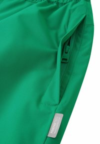 Zielone wodoodporne spodnie wykonane z gładkiego, trwałego materiału. Posiadają kieszeń na zamek błyskawiczny oraz metkę z logo "reimaTEC WATERPROOF."