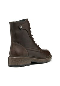 Bottine en cuir marron avec une semelle texturée, un devant lacé et un bouton sur le côté. Présente une pointe arrondie et un design robuste.
