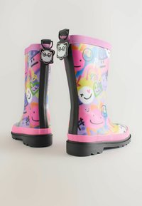 Stivali da pioggia in gomma colorati con un design fantasioso che presenta faccine sorridenti, cuori e forme astratte; dettagli rosa e schienali neri flessibili.