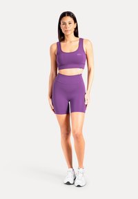Set med sport-bh och shorts i lila, tillverkade av mjukt och stretchigt tyg. Har en figurnära passform och minimala märkesdetaljer.