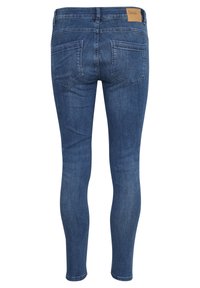 Vékony kék farmernadrág, elhalványodott felülettel, hátsó yoke-kal, két hátsó zsebbel és egy barna bőr márkájú folttal a derékrészen.