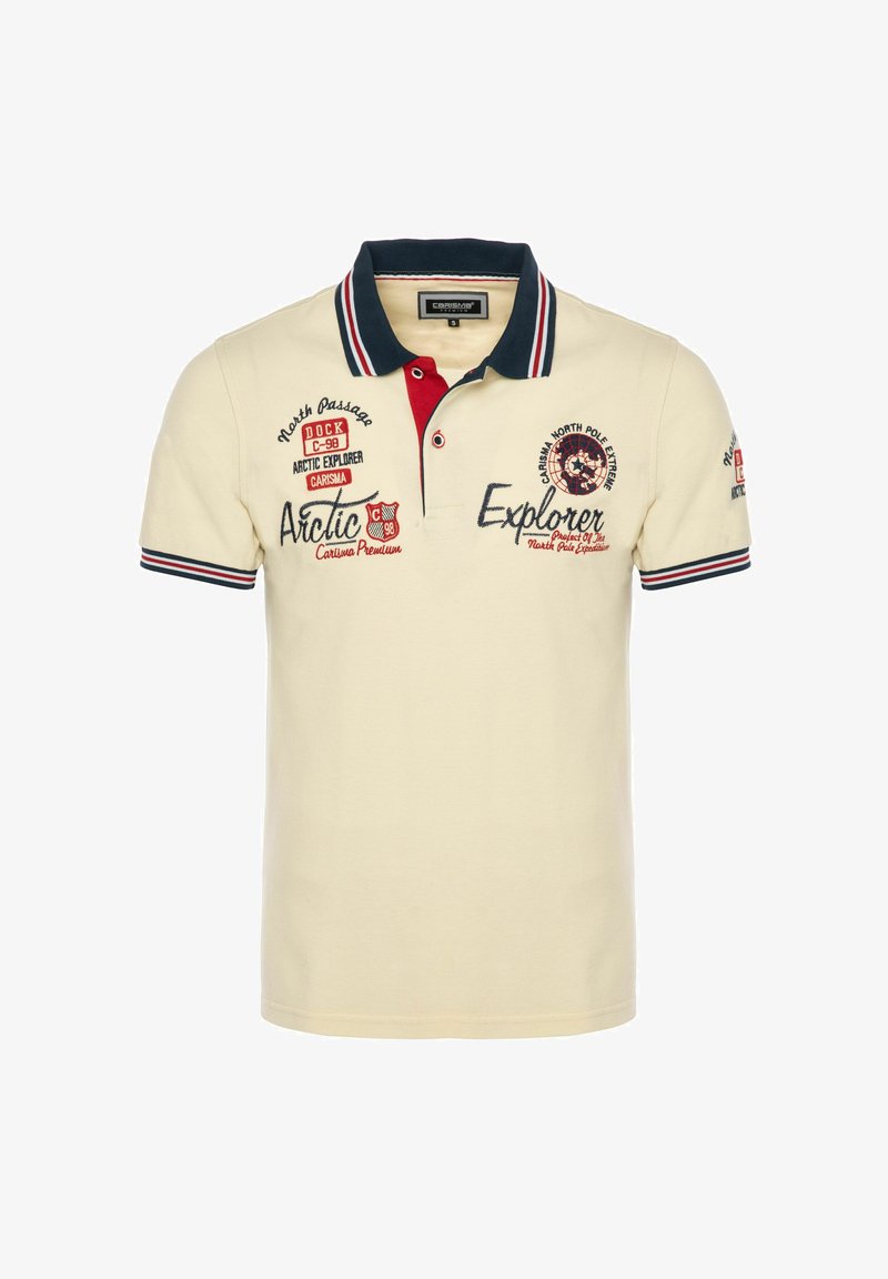 Polo beige con cuello azul marino y rayas rojas y blancas, con texto y parches bordados con tema del Explorador Ártico y el Polo Norte.