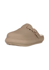 Beige liukaspas chaussure avec un extérieur texturé, une sangle réglable, une forme contourée et un intérieur rembourré pour le confort. Fabriqué à partir d'un matériau flexible.