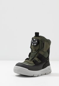 Stivale da neve verde e nero con superiore in rete, sistema di serraggio BOA, suola in gomma e punta rinforzata per resistenza. Superfici e accenti testurizzati.