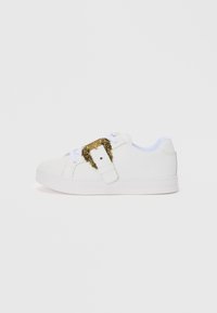 White sneaker with a smooth texture, featuring a gold decorative buckle and brand detail on the side; flat sole and lace closure design.