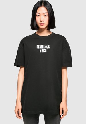 Black oversized t-shirt made of cotton. Features "REBELLIOUS MINDS" printed in white on the front. Short sleeves, round neckline.