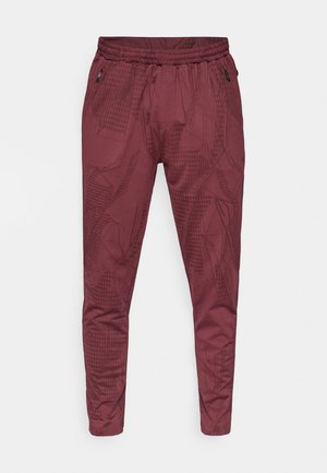 Calças de atletismo bordeaux com um padrão geométrico abstrato preto, cintura elástica e design afunilado. Apresenta bolsos laterais com fecho de correr.