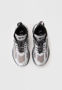 Silver and black mesh sneakers with a textured surface, featuring black laces, a padded collar, and contrasting accents on the sides.