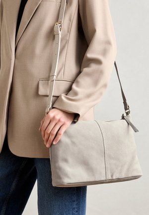 Borsa in suede grigia con un design strutturato, dotata di una lunga tracolla regolabile e di un sottile dettaglio cucito sul davanti.