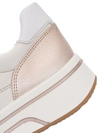 Close-up of sneaker heel with white leather upper, light beige textured panel, thick white midsole, and light brown rubber outsole.
