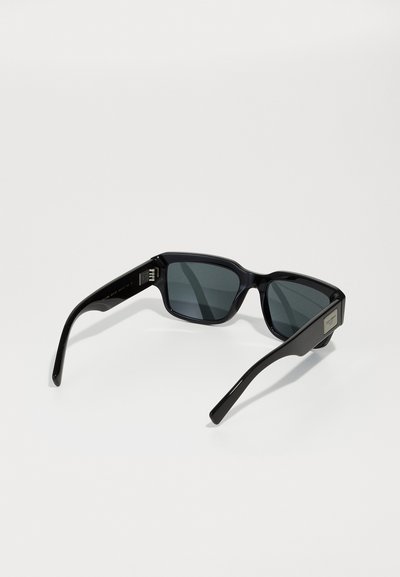 Black plastic sunglasses with dark gray lenses, rectangular frames, and straight arms. Features logo accents on the sides.