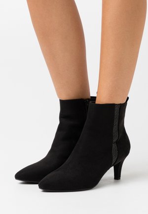 Bottines en suède noir à bout pointu et à panneau latéral texturé. Elles présentent un petit talon et une fermeture éclair.