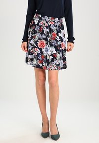 Floral skirt featuring a navy background with colorful patterns. Elastic waistband provides comfort. Skirt length is above the knee.