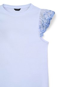 Top senza maniche in cotone bianco caratterizzato da volant in pizzo azzurro chiaro su una spalla, decorato con piccoli motivi floreali e bordi scallop.