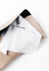 Saculeț din piele texturată de culoare bronz, cu interior negru, parțial deschis. Material alb cu logo-ul "TNTUUM" vizibil în interior.