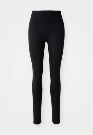Zwarte hoge naadloze legging met een aansluitende silhoeet op een witte achtergrond.