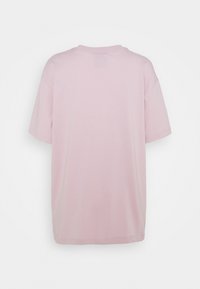 Ljusrosa bomullströja med avslappnad passform, korta ärmar och rundad halsringning, med en slät textur och utan distinkta mönster.