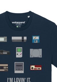 T-shirt en coton bleu marine avec des motifs graphiques de consoles de jeux rétro et de cartouches de différentes couleurs, avec le texte "JE SUIS FAN."