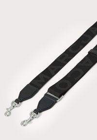 Curea de geantă din material textil negru, cu text îndoit "MARCA", având accente din piele și clipsuri metalice argintii la fiecare capăt pentru atașare.