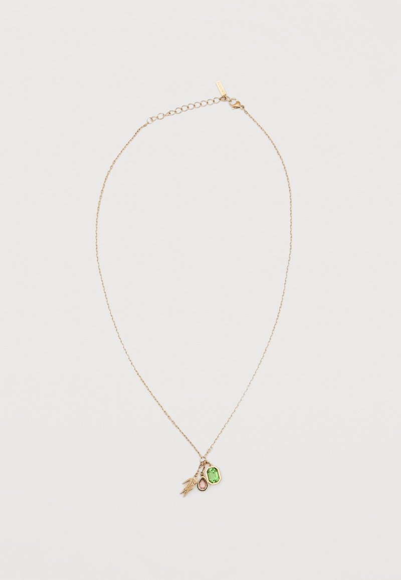 Collier délicat en chaîne d'or avec trois breloques : un petit oiseau, une gemme en forme de larme rose, et une gemme rectangulaire verte plus grande.