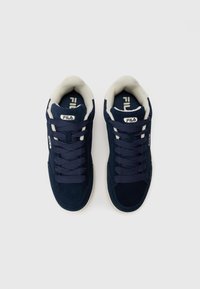Navy blue suede sneakers with beige accents, round toe, and lace-up design. Logo on tongue and side. Smooth texture, cushioned collar.