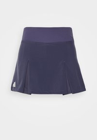 Falda deportiva azul marino con una cinturilla ancha, pliegues en el dobladillo y detalle de logo. Fabricada con una tela ligera y lisa con un ligero brillo.