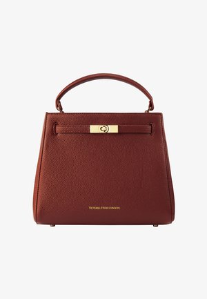 Struktureret bordeaux rød læderhåndtaske med en topanhænger og en lukning med guldspænde. Har et mærkelogo på forsiden.