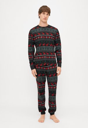 Schwarzes Pyjama-Set mit einem geometrischen Muster, das rote Rentiere, grüne Bäume und weiße Schneeflocken zeigt; weicher Stoff mit langen Ärmeln und Bündchen.