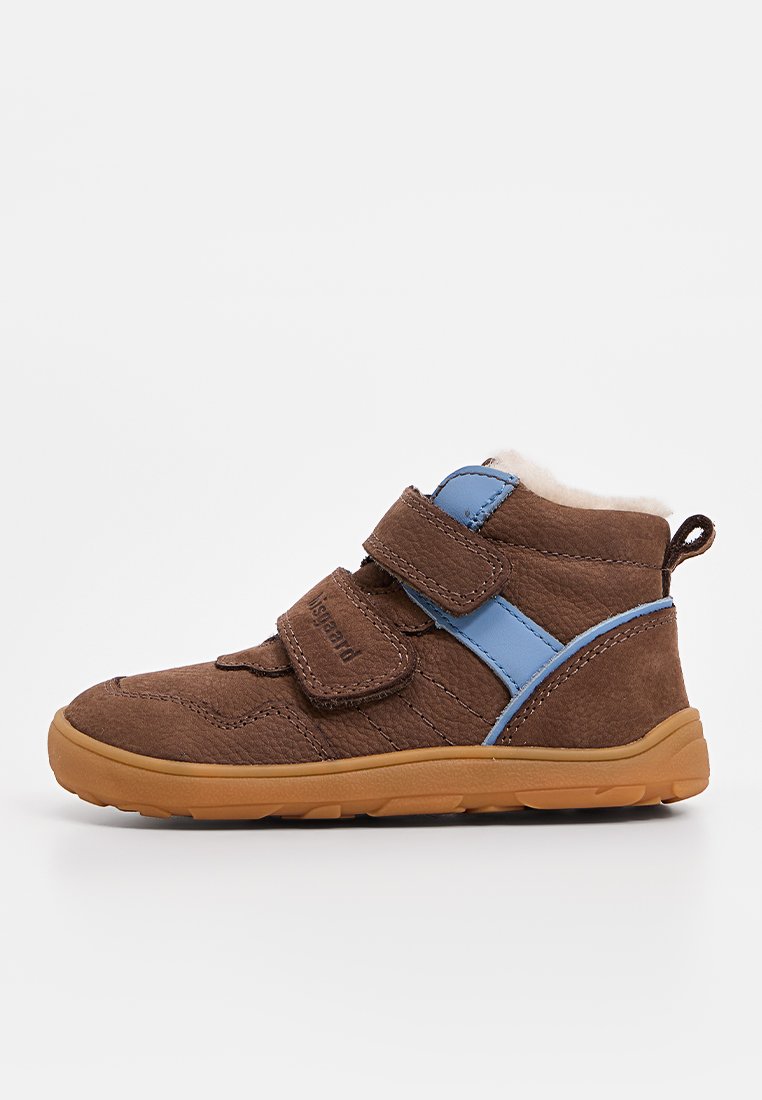 Bottine en suedine marron avec deux bandes Velcro bleues, semelle en caoutchouc beige et doublure douce. Présente un dessus texturé et des accents latéraux.