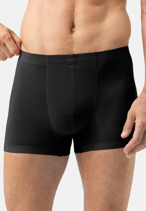 Black boxer briefs with a textured fabric, featuring a branded waistband. The design is form-fitting with a mid-thigh length and stitched seams.