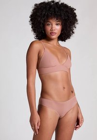 Set bikini rosa chiaro composto da un reggiseno a triangolo con spalline sottili e slip a vita bassa, realizzato in materiale liscio ed elastico.