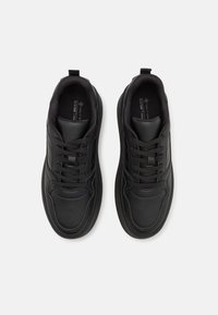 Czarne trampki z gładką skórzaną cholewką, sznurowanym designem, wyściełanym kołnierzem i teksturowaną gumową podeszwą. Posiadają subtelne akcenty w postaci przeszyć.