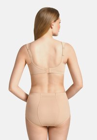 Beige beha en slip set, naadloos ontwerp, zachte stof, verstelbare bandjes, haaksluiting aan de achterkant, gladde textuur zonder zichtbare patronen.