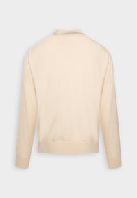 Cárdigan beige de manga larga y cuello redondo con un acabado texturizado y dobladillo acanalado. Diseño simple y acogedor sin cierres visibles ni patrones.