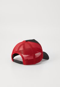 Rød og sort truckerhat med meshnakke, buet skygge og justerbar snapback-lukning, med en glat sort frontpanel.