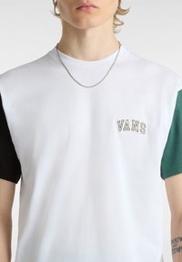 Kurzärmliges T-Shirt mit weißem Körper und grünen sowie schwarzen Ärmeln, mit gesticktem "VANS"-Logo auf der Brust. Aus Baumwollmaterial.