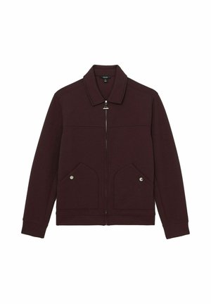 Burgundy színű dzseki, galléros nyakkal, elülső cipzárral, két nagy rávarrt zsebbel és ezüstszínű fém kiegészítőkkel. Puha anyagból készült.