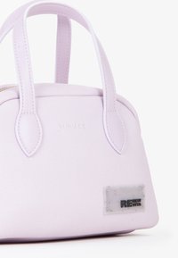 Borsa a mano lilla con superficie testurizzata, forma arrotondata, manici corti e un'etichetta con il logo "RENEW VITA" in plastica trasparente con macchie colorate.