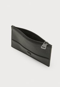 Black leather wallet with a textured surface, zip closure, and a smooth accent band. Features a silver hardware logo detail on the front.