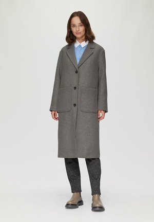 Grijze wol blend jas met een ingesneden kraag, twee voorzakken en knoopsluiting. Draag over een blauwe blouse en zwarte met patroonkleding.