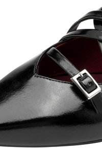 Scarpa flat in vernice nera con punta a mandorla, caratterizzata da una fascia decorativa e un dettaglio con fibbia; interno foderato in tessuto bordeaux.