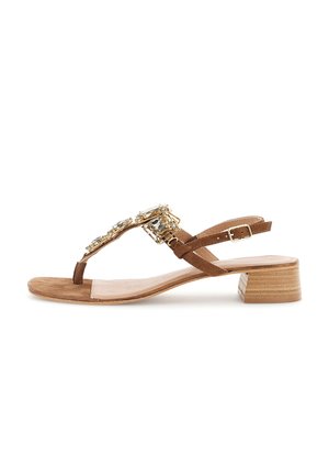 Brun ruskindsandal med lav blokhæl, tæresnor, ankelspænde og store rektangulære krystaldekorationer på den øverste rem.